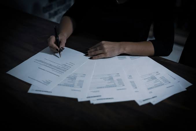 Profissional analisa documentos para reduzir encargos no Simples Nacional.